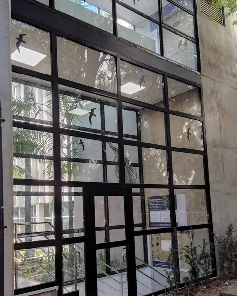 Fachada de vidro com esquadria de ferro instalada pela ARB Vidros em obra comercial