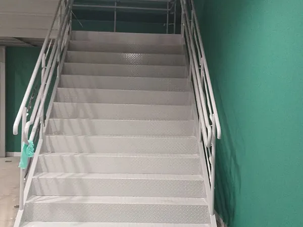 Escada com corrimão de inox feita pela ARB Vidros em obra comercial